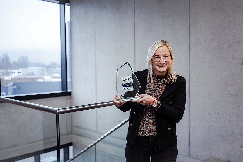 AfB gewinnt Leading Employer Award. Yvonne Cvilak hält die Auszeichnung lächeln in die Kamera.