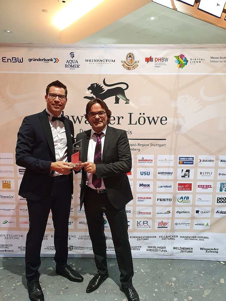 Daniel Büchle und Mike Reif halten den Wirtschaftspreis Schwarzer Löw in der Hand.