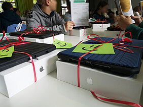 Als Geschenk verpackte nagelneue iPads liegen in der Schule auf einem Tisch.