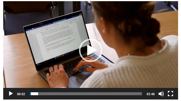 Screenshot vom Erklärfilm des Franziskanergymnasium Kreuzburg: Ein Mädchen sitzt in der Schule an einem Tisch und tippt auf ihrem Tablet-PC, man blickt ihr über die Schulter.